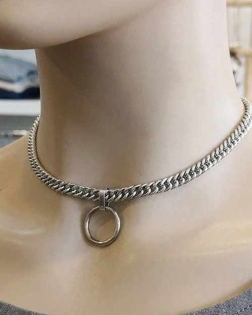 Mannequin wearing a silver chain necklace with a circular pendant in a store setting.