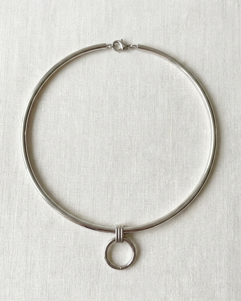 Silver necklace on a light gray textured background