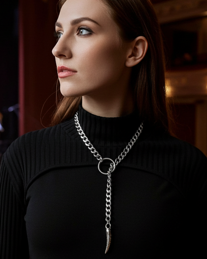 Woman in a black sweater with a long necklace in an empty theater.