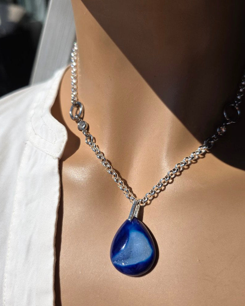 Mannequin wearing a necklace with a blue pendant