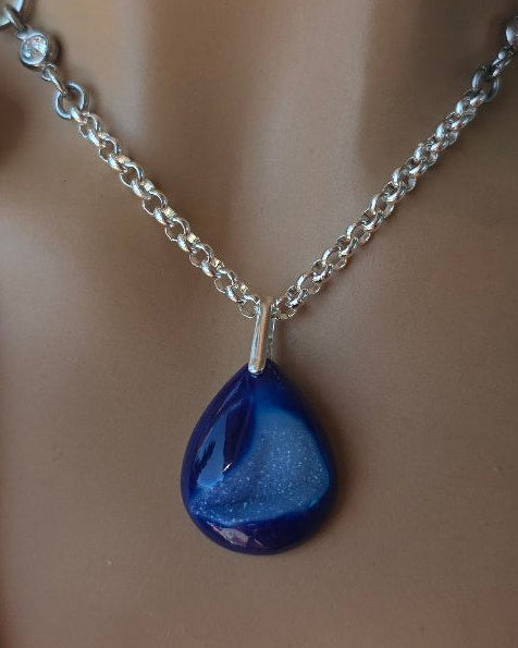 Mannequin wearing a necklace with a blue pendant