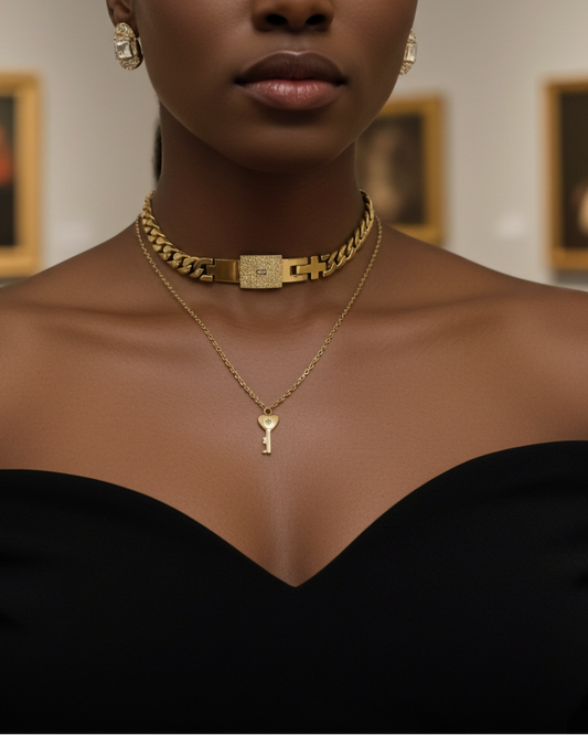 Woman wearing a gold necklace with a key pendant in an art gallery setting