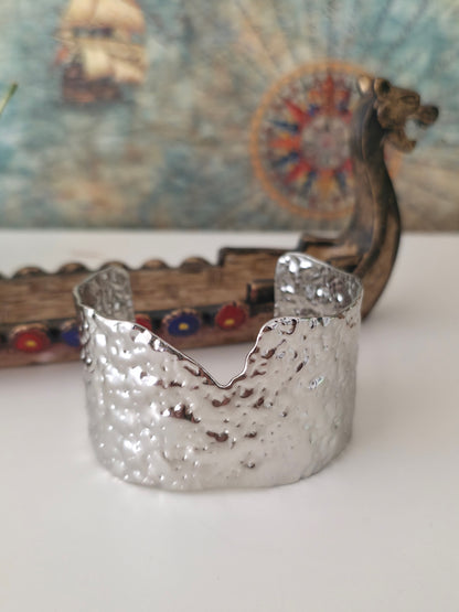 Silver candle holder on a white surface with a colorful background
