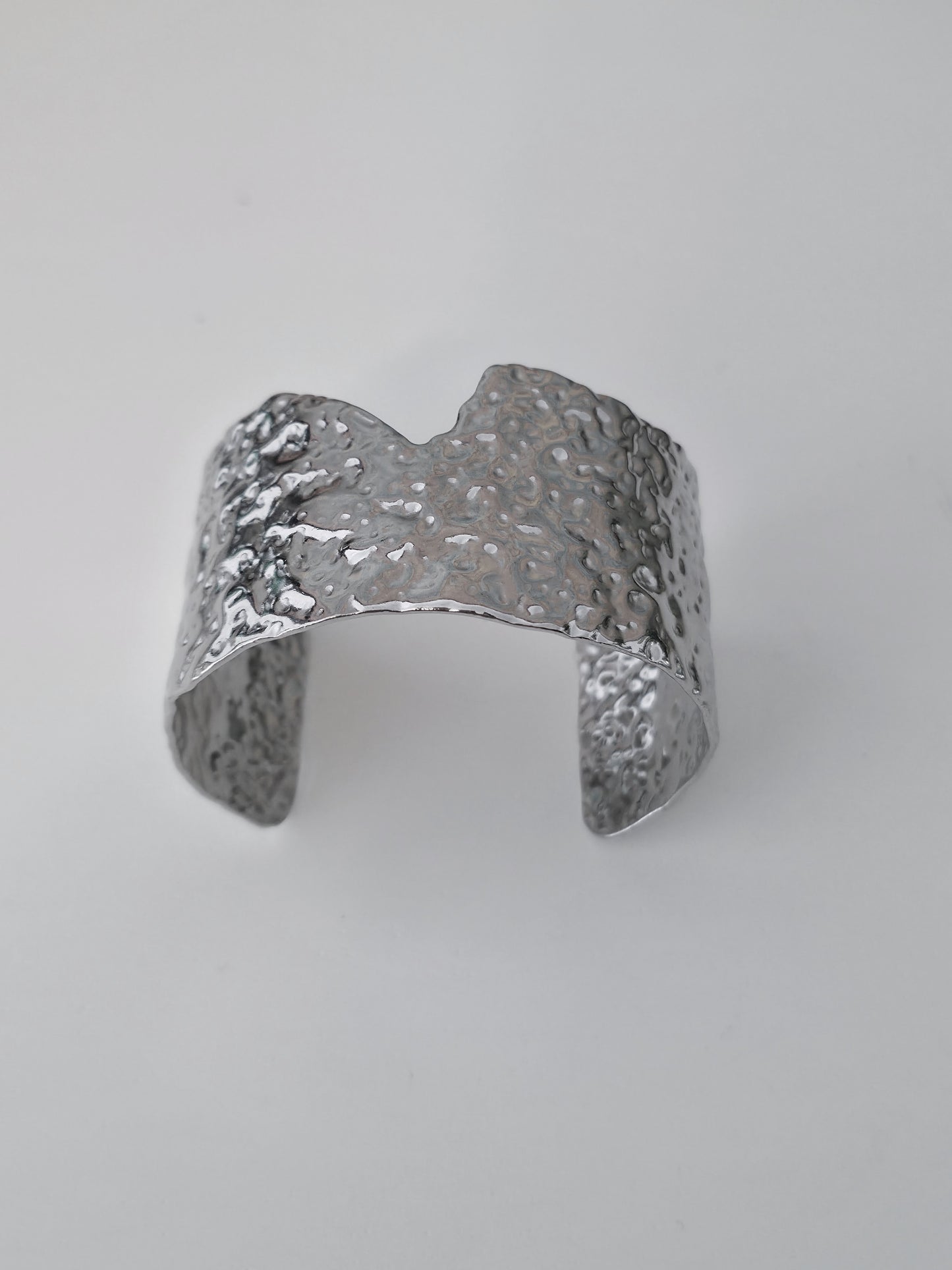 Silver textured ring on a light gray background