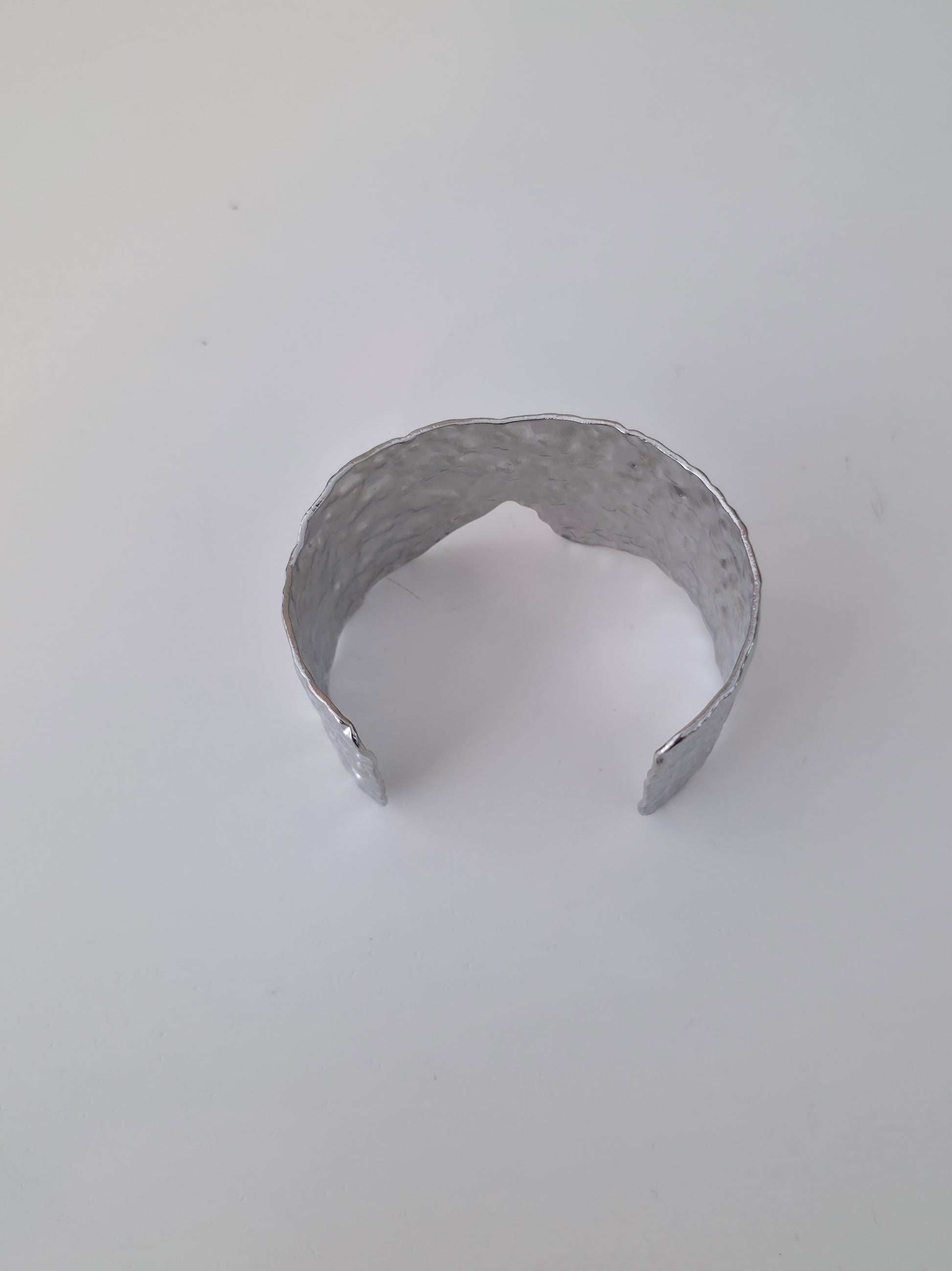 Silver bracelet on a light gray background