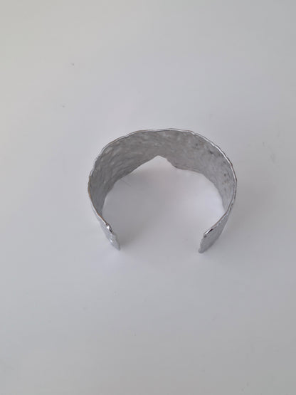 Silver bracelet on a light gray background