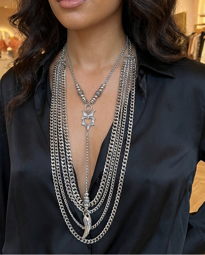 Woman wearing a black shirt with layered silver necklaces in a store setting