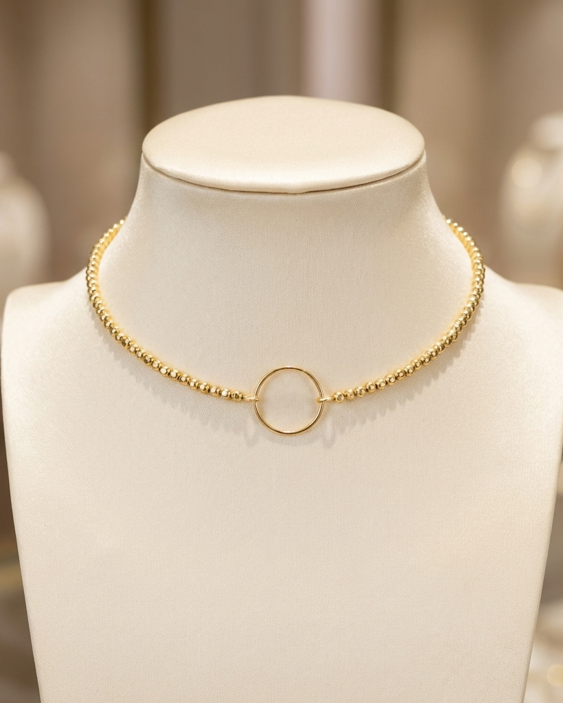 Gold necklace on a mannequin bust with a blurred background
