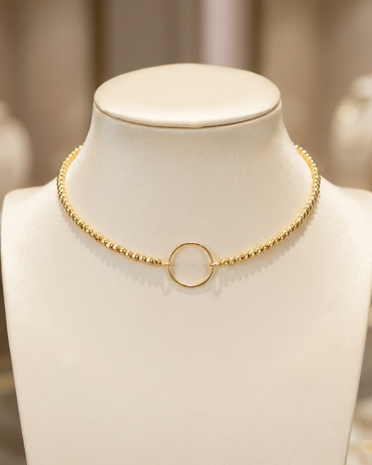 Gold necklace on a mannequin bust with a blurred background