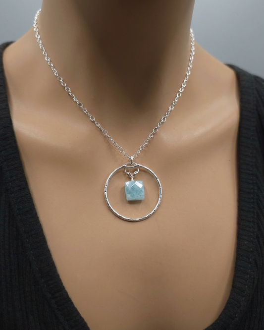 Necklace with a pendant featuring a blue stone on a mannequin