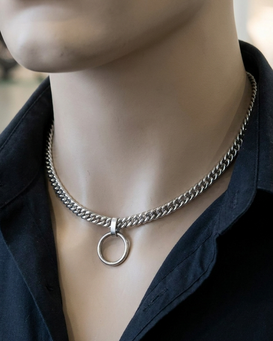 Mannequin wearing a black shirt with a silver chain necklace featuring a circular pendant.