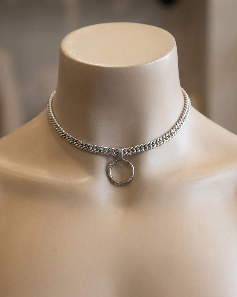 Silver chain necklace on a mannequin bust with a blurred background