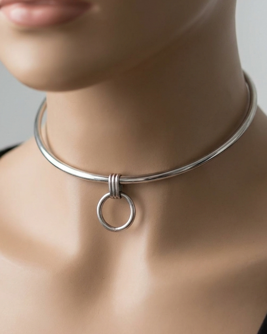 Mannequin wearing a silver necklace with a circular design on a neutral background