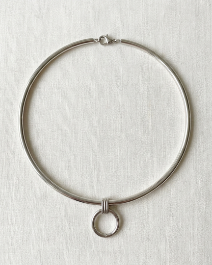 Silver necklace on a light gray textured background