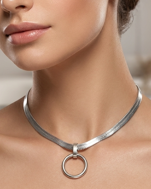 Woman wearing a silver necklace in an indoor setting