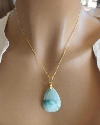Mannequin wearing a necklace with a green pendant
